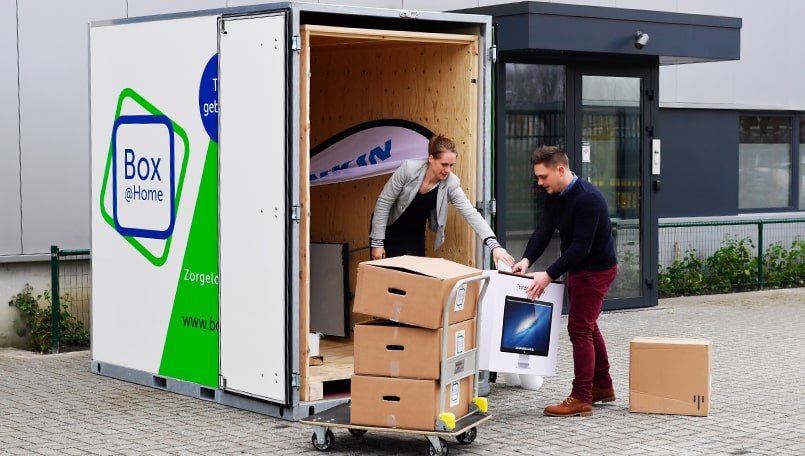 Two colleagues load the contents of their office into a Large Box from Box@Home